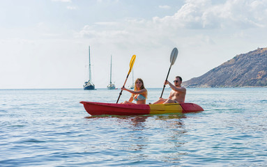 Naklejka premium Couple exploring calm tropical bay by kayak.