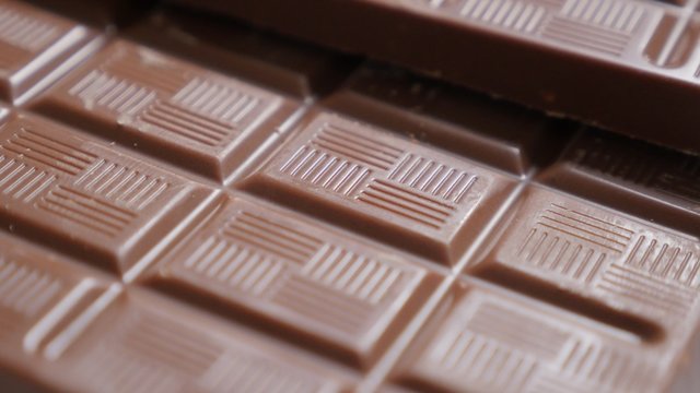 Dark chocolate bars and blocks popular confection shallow DOF tilting 4K 2160p UltraHD footage - Slow tilt over chocolate bar background close-up 4K 3840X2160 30fps UltraHD video 
