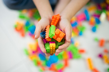 Kid hand holding blocks toy