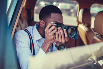 A blackman shooting on dslr from the car.