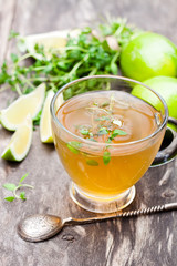 Green  tea with thyme and lime on rustic wooden background