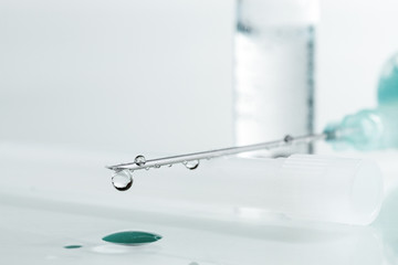 Medical syringe with injection solution drop. Shallow depth of f