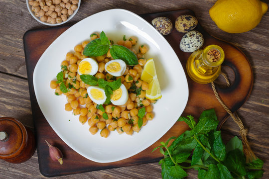 Mediterranean cuisine. Dish of chickpeas with mint, olive oil and lemon sauce on a wooden background
