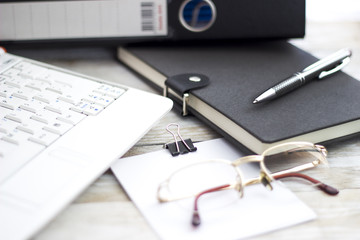 Office workplace with laptop, folders and agenda on wood table