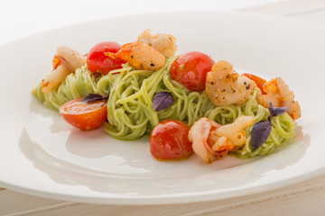 A plate of delicious italian pasta: spaghetti with shrimps and cherry