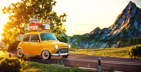 Obraz na płótnie Canvas Cute little retro car goes by wonderful countryside road at sunset