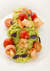 A plate of delicious italian pasta: spaghetti with shrimps and cherry