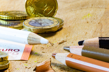 A white pencil surrounded by money is facing poor black and brown pencils in this racism and money...