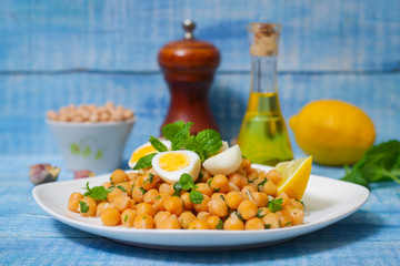 Mediterranean cuisine. Dish of chickpeas with mint, olive oil and lemon sauce on a wooden background
