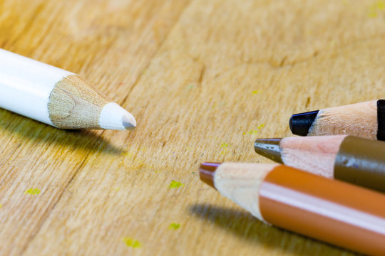 A white pencil is facing black and brown pencils in this racism pencil concept.