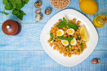 Mediterranean cuisine. Dish of chickpeas with mint, olive oil and lemon sauce on a wooden background