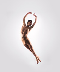 Fototapeta na wymiar Athletic ballet dancer performing in a studio