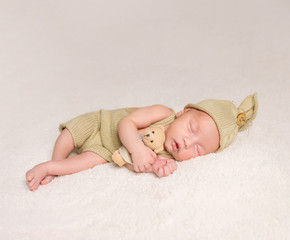 sweet newborn baby sleeping in costume and hat