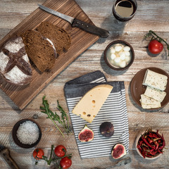 bread with cheeses and grapes on wooden background