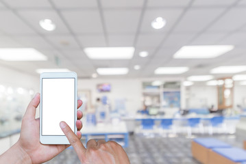 Man using touch screen mobile phone with blurry image of Office
