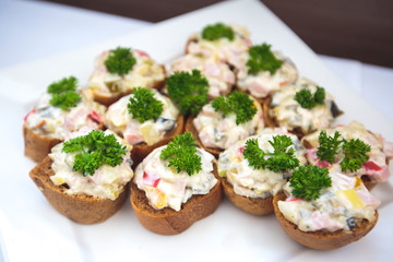 Beautifully decorated catering banquet table with different food snacks and appetizers with sandwich, caviar, fresh fruits on corporate christmas birthday party event or wedding celebration