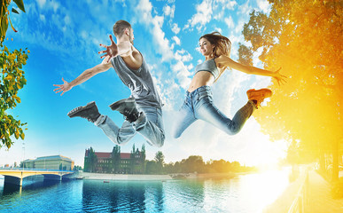 Two jumping dancers on an urban background