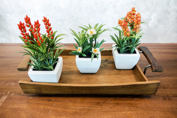 Flower in the white vase on a wood table