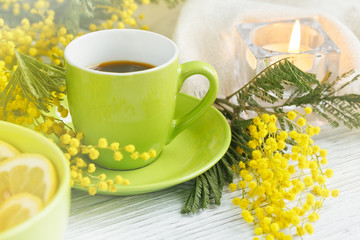 mimosa, lemon and coffee on light wooden background