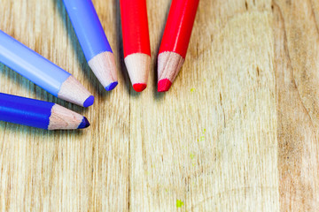 Colorful close up set of pencils on a wooden table.
