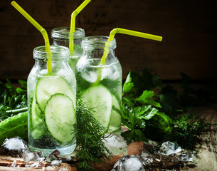 Refreshing cold drink of cucumber and herbs in glass bottles, se