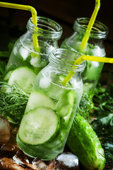 Refreshing cold drink of cucumber and herbs in glass bottles, se
