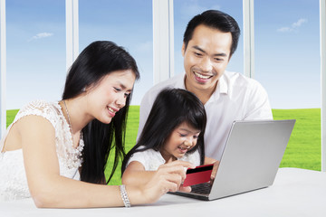 Young parents and their child buy online