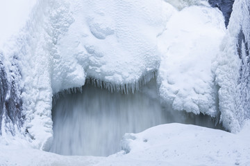 Icicles and snow near flowing water