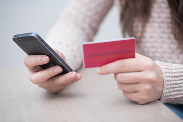 Woman holding credit card while using computer