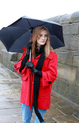 Young woman holding an umbrella from sleet and rain