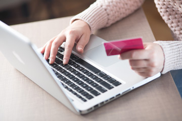 Woman holding credit card while using computer