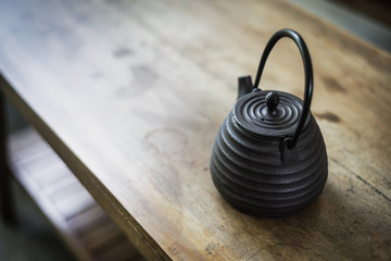Naklejka na ściany i meble japanese traditional black tea pot on rustic wooden table