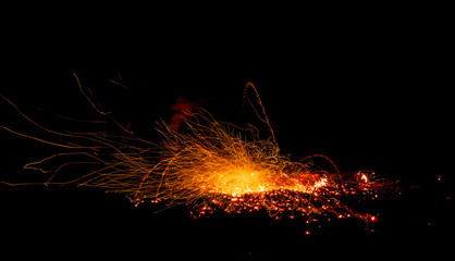 Fototapeta na wymiar Sparks from the fire embers explosion on a black background