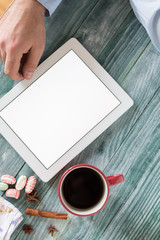 Obraz premium hand using mockup tablet similar to ipad style on wood desk whit