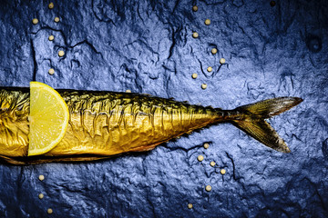 Smoked mackerel  lying on the stone slab.