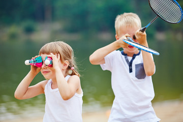 Kinder spielen mit Federball und Schläger