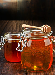 Composition with jars of honey on wooden table
