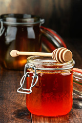 Composition with jars of honey on wooden table
