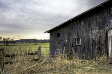 Weathered barn to the right with fence