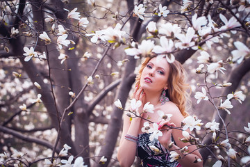 Fototapeta premium Beauty smiling woman near white magnolia