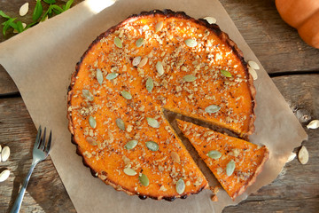 pumpkin tart with cream and cinnamon on rustic background, top v