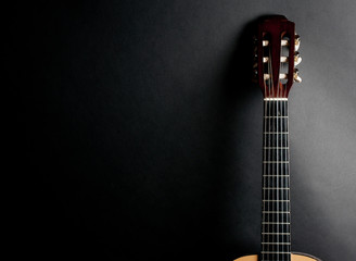 Neck of an old acoustic guitar on a black background (with copy space)