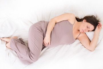 Obraz premium the pregnant woman has a rest on a bed 