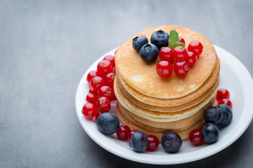 Stack of pancakes with blueberry and fresh berry.