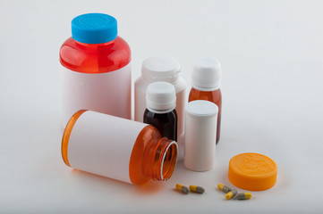 Colorful pharmaceutical bottles and pills on white
