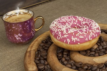 Fresh coffee and a donut. Sweet treats to hot coffee. Traditional dessert, filled donut.
