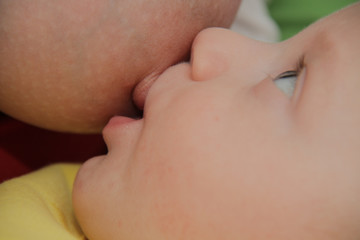 Mom breastfeeding baby boy with breast milk