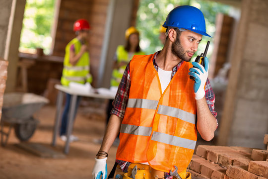 Construction Worker Talking On Walkie Talkie At Site