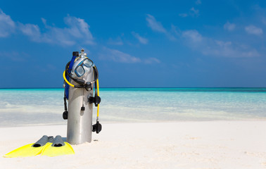 Taucherflasche mit Taucherbrille, Flossen und Atemregler am Strand