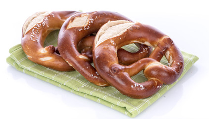 Fresh bavarian pretzels on dish towel, isolated on white